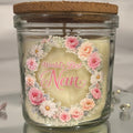 Candle in a glass jar with floral design and 'World's Best Nan' text on a white background